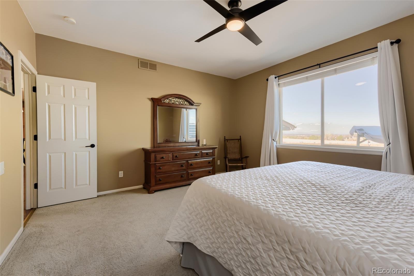 3897 Mallard Lane Highlands Ranch, CO 80126 - Photo 15 of 50 a spacious bedroom with a bed and a dresser next to a window
