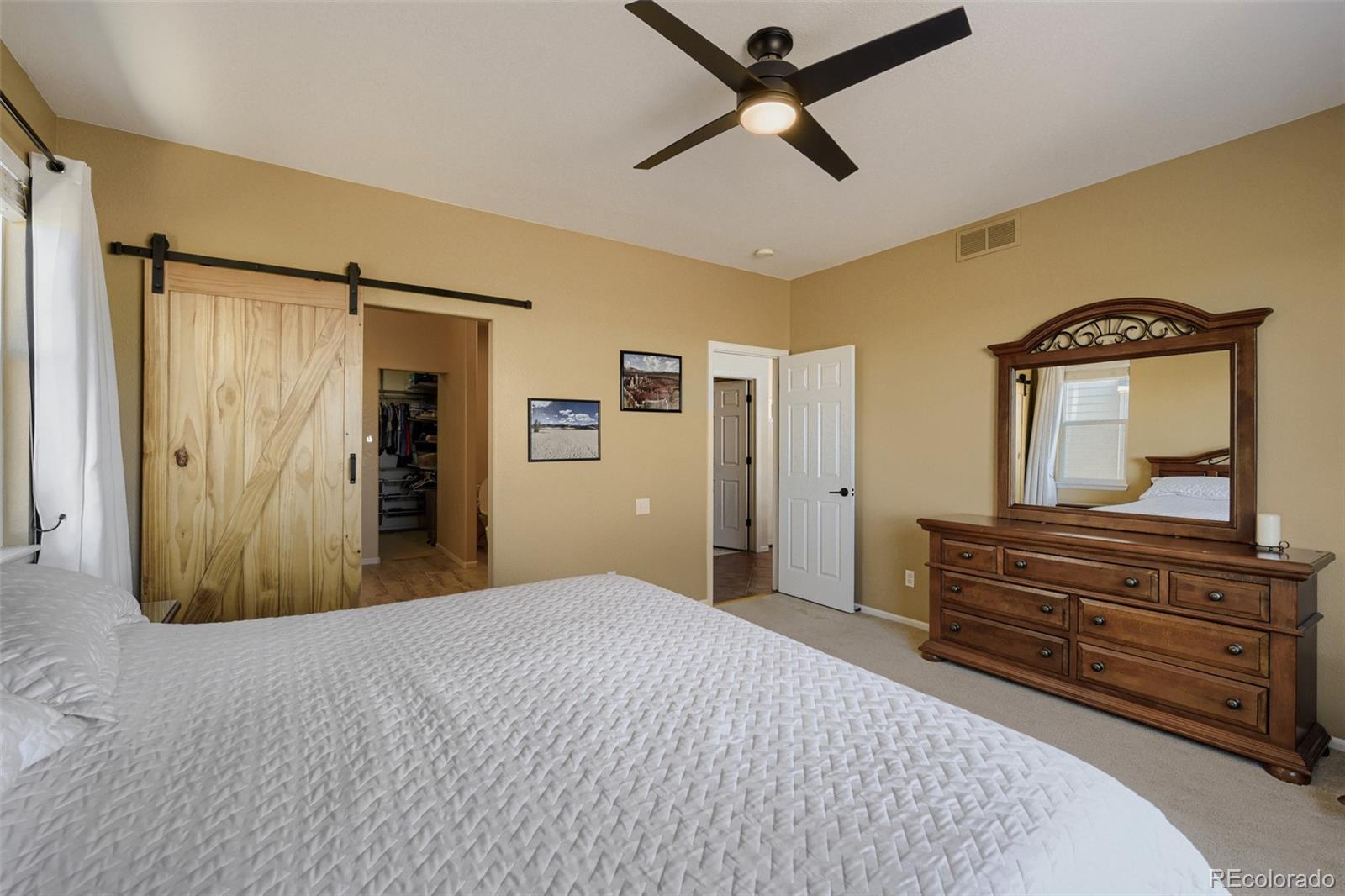3897 Mallard Lane Highlands Ranch, CO 80126 - Photo 16 of 50 a bedroom with a large bed and a chandelier