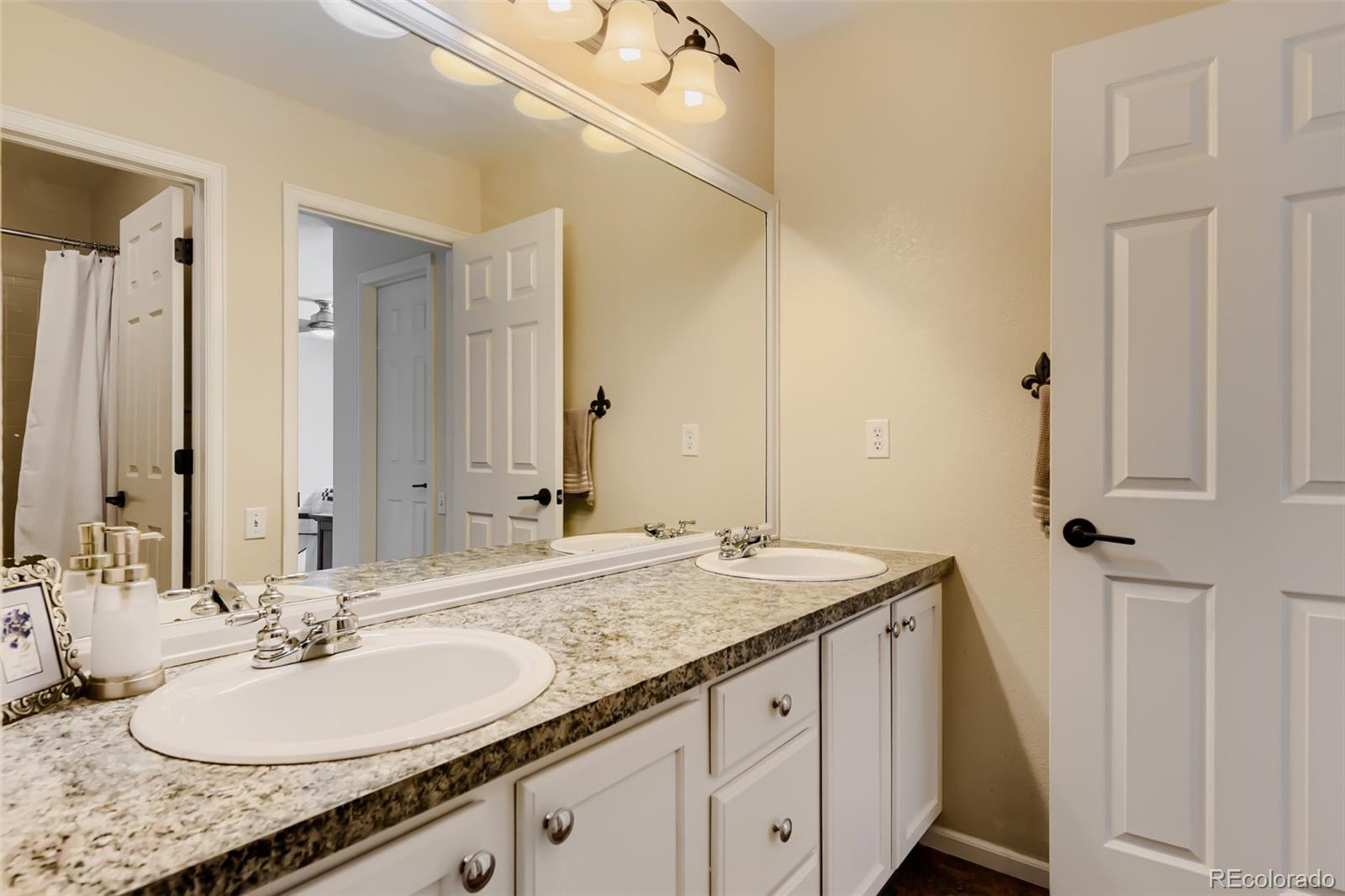 3897 Mallard Lane Highlands Ranch, CO 80126 - Photo 25 of 50 a bathroom with a granite countertop sink and a mirror