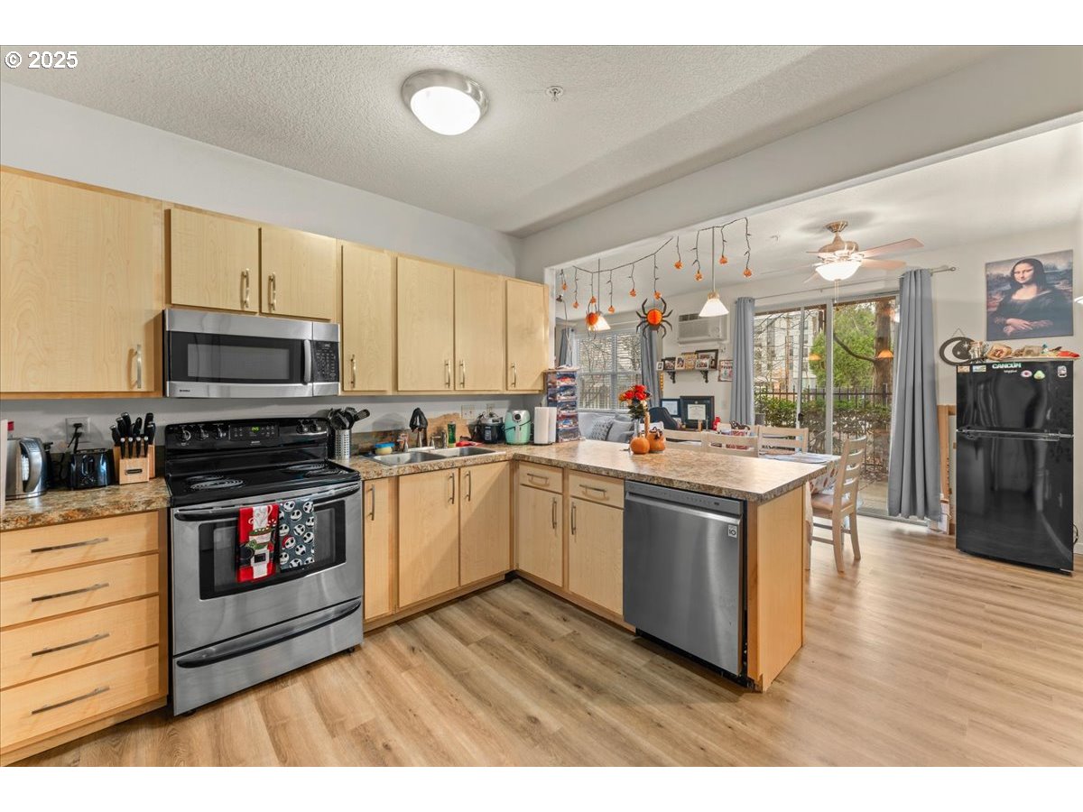 400 Northeast 100th Avenue, Unit 101 Portland, OR 97220 - Photo 6 of 22 a kitchen with stainless steel appliances granite countertop a stove a sink and a microwave