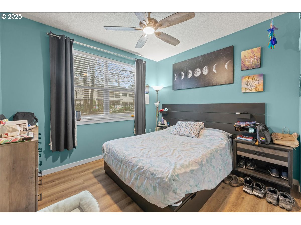 400 Northeast 100th Avenue, Unit 101 Portland, OR 97220 - Photo 7 of 22 a bedroom with a bed and a chandelier