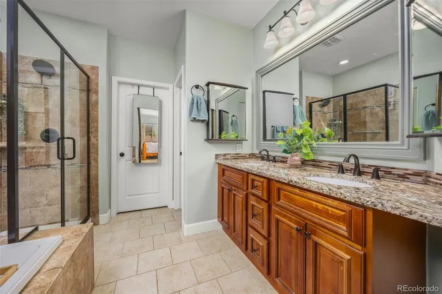 a bathroom with a granite countertop sink mirror and shower