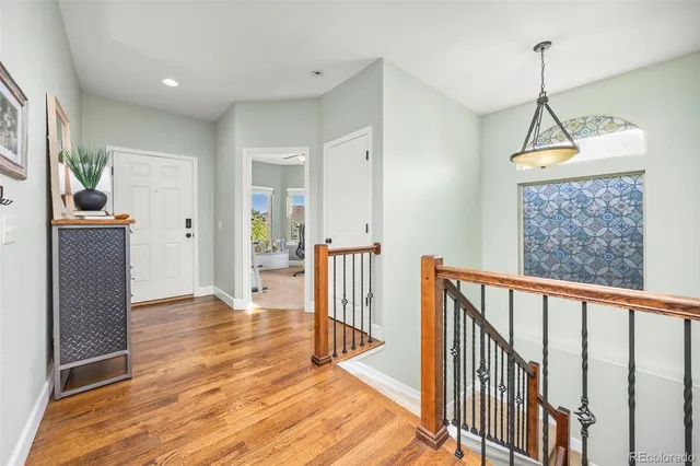 a view of hallway with wooden floor and stairs