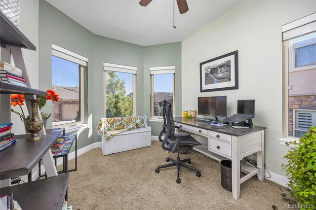 a view of a workspace with furniture and a window
