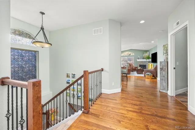 a view of a hallway with wooden floor and a chandelier