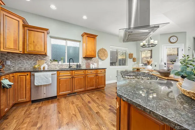 a large kitchen with granite countertop a sink and cabinets