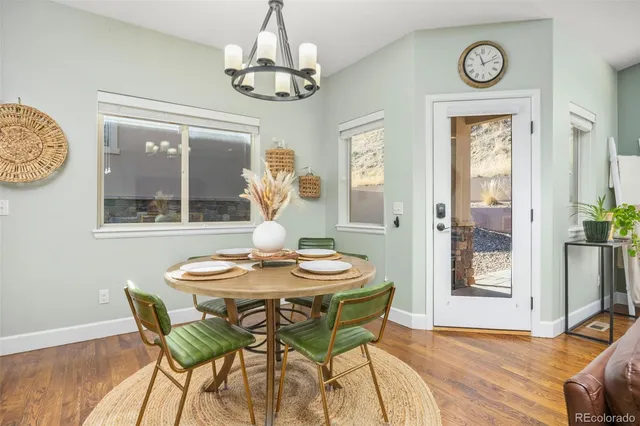 a dining room with furniture wooden floor and a chandelier