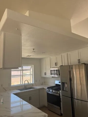 a kitchen with granite countertop a refrigerator and a sink