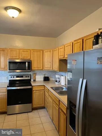 a kitchen with stainless steel appliances a stove sink and refrigerator