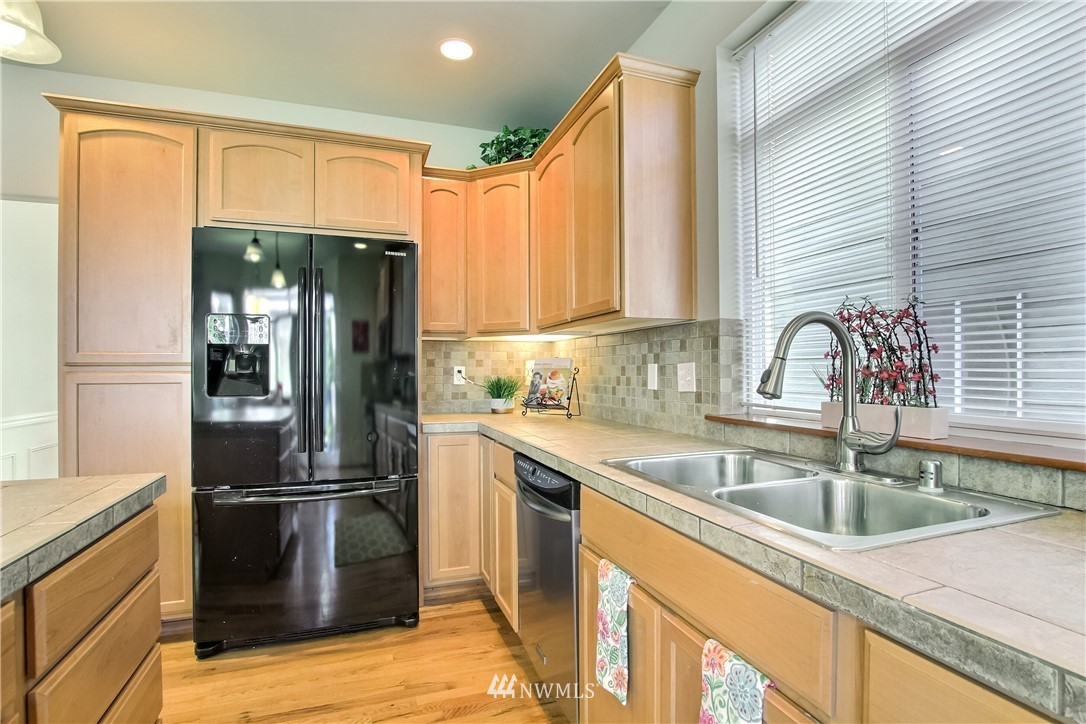 3827 160th Place Southeast Bothell, WA 98012 - Photo 15 of 40 a kitchen with a refrigerator sink and cabinets