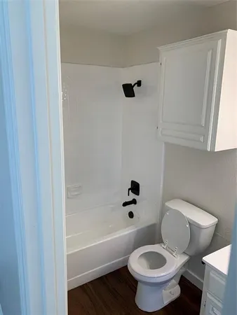 a white toilet sitting next to a bath tub