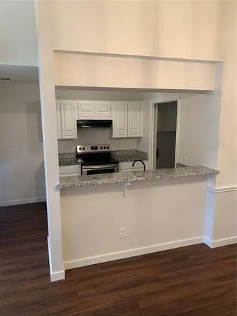 a room with granite countertop a sink and a microwave