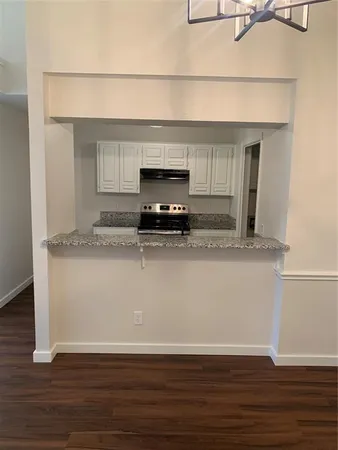 a view of kitchen with granite countertop cabinets and wooden floor