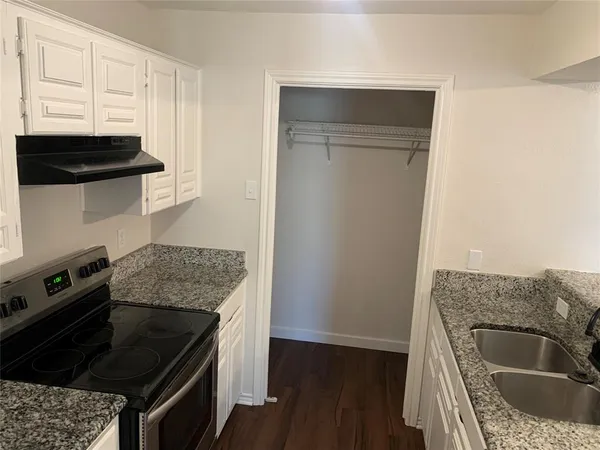 a kitchen with granite countertop a stove and a microwave