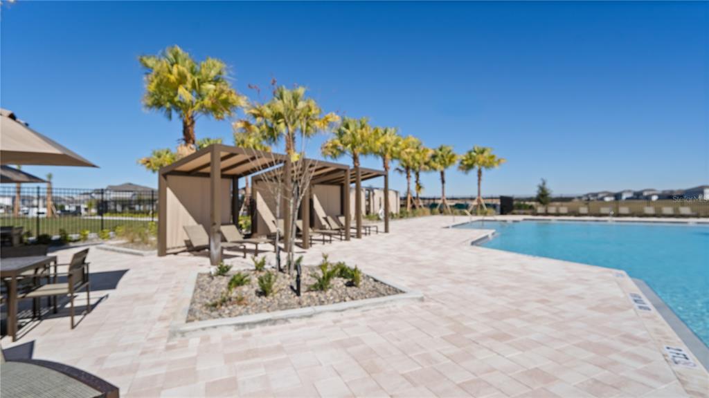 2916 Transformation Way Clermont, FL 34714 - Photo 83 of 91 a view of a swimming pool with a table and chairs