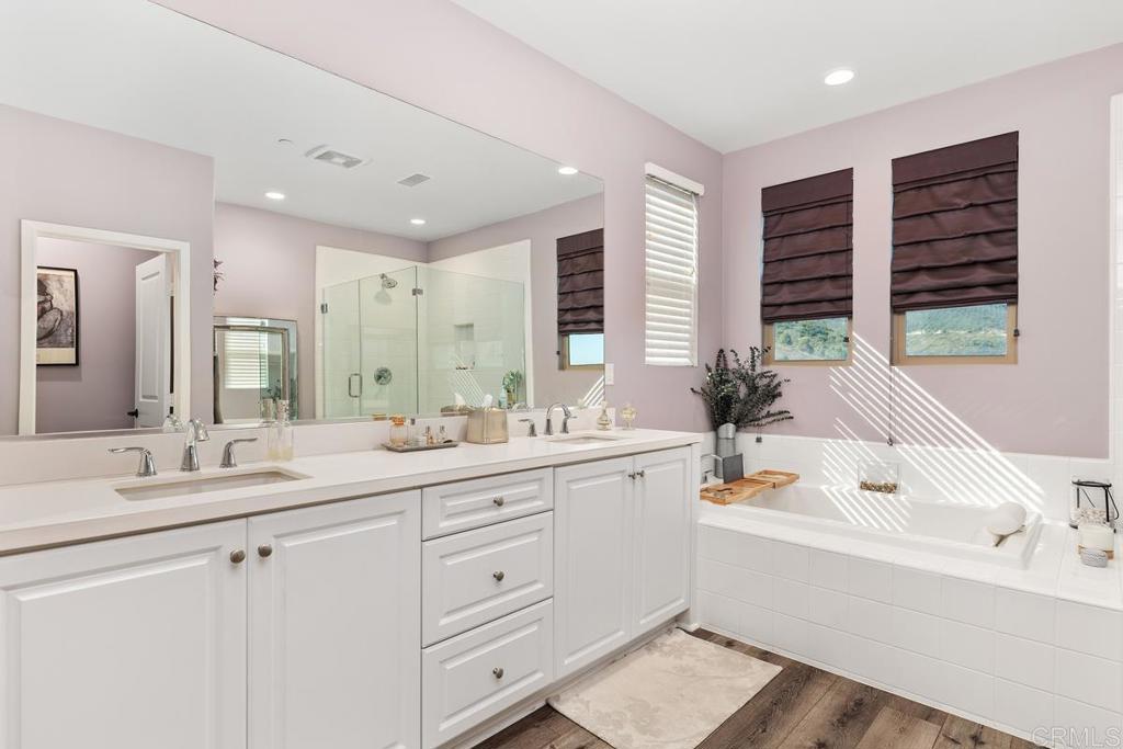 655 Merit Drive San Marcos, CA 92078 - Photo 20 of 35 a bathroom with a double vanity sink large mirror and a bathtub