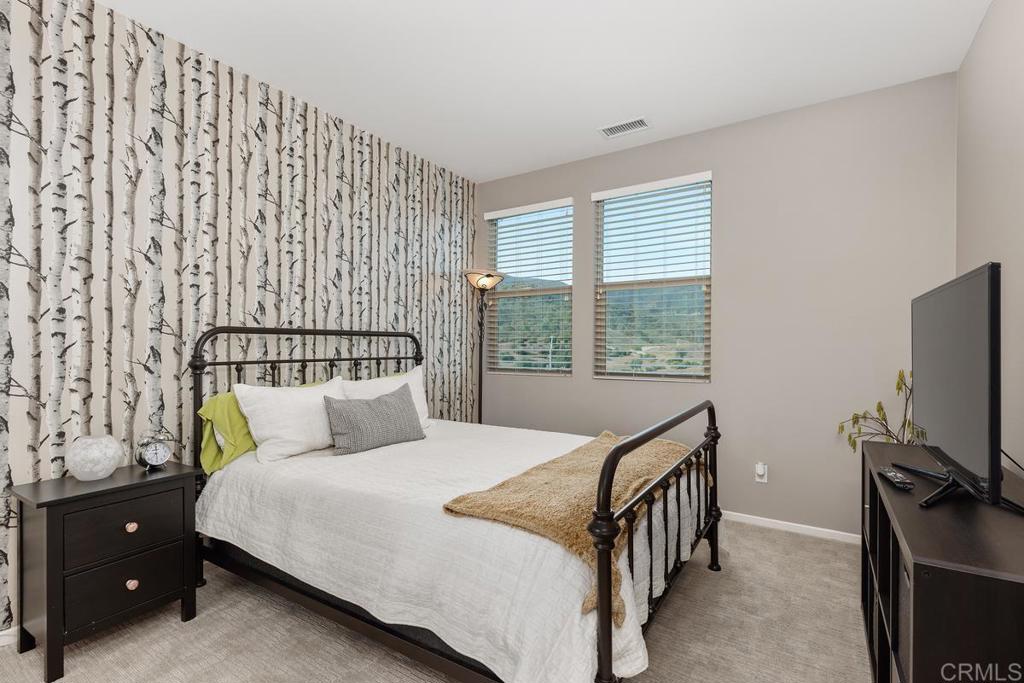 655 Merit Drive San Marcos, CA 92078 - Photo 23 of 35 a bedroom with a bed a mirror on dresser and a window