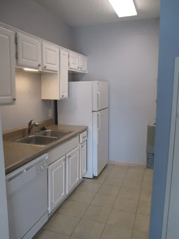 a kitchen with white cabinets and white appliances