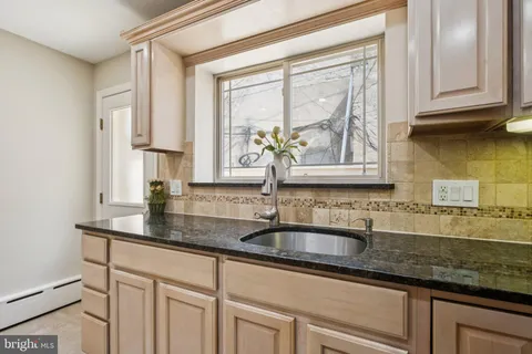 a kitchen with kitchen island granite countertop a sink stove and refrigerator