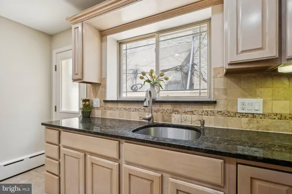 a kitchen with kitchen island granite countertop a sink stove and refrigerator