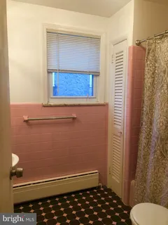 a bathroom with a toilet and a shower