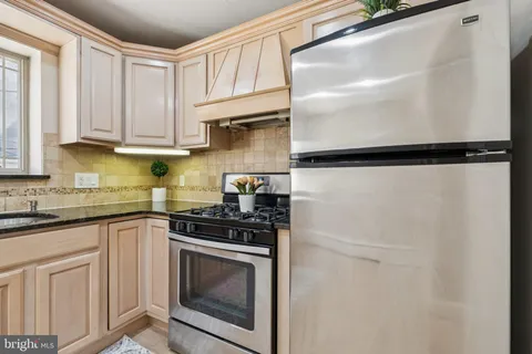 a kitchen with a refrigerator sink and cabinets