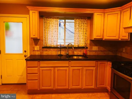a kitchen with granite countertop a sink and a wooden cabinets