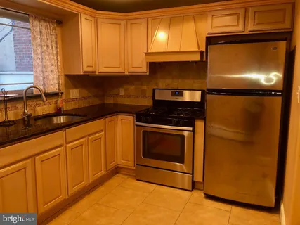 a kitchen with granite countertop cabinets stainless steel appliances and a counter space