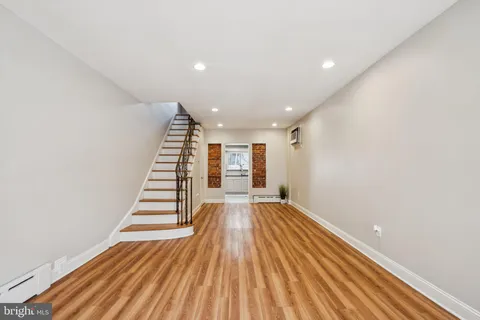 a view of an empty room with wooden floor