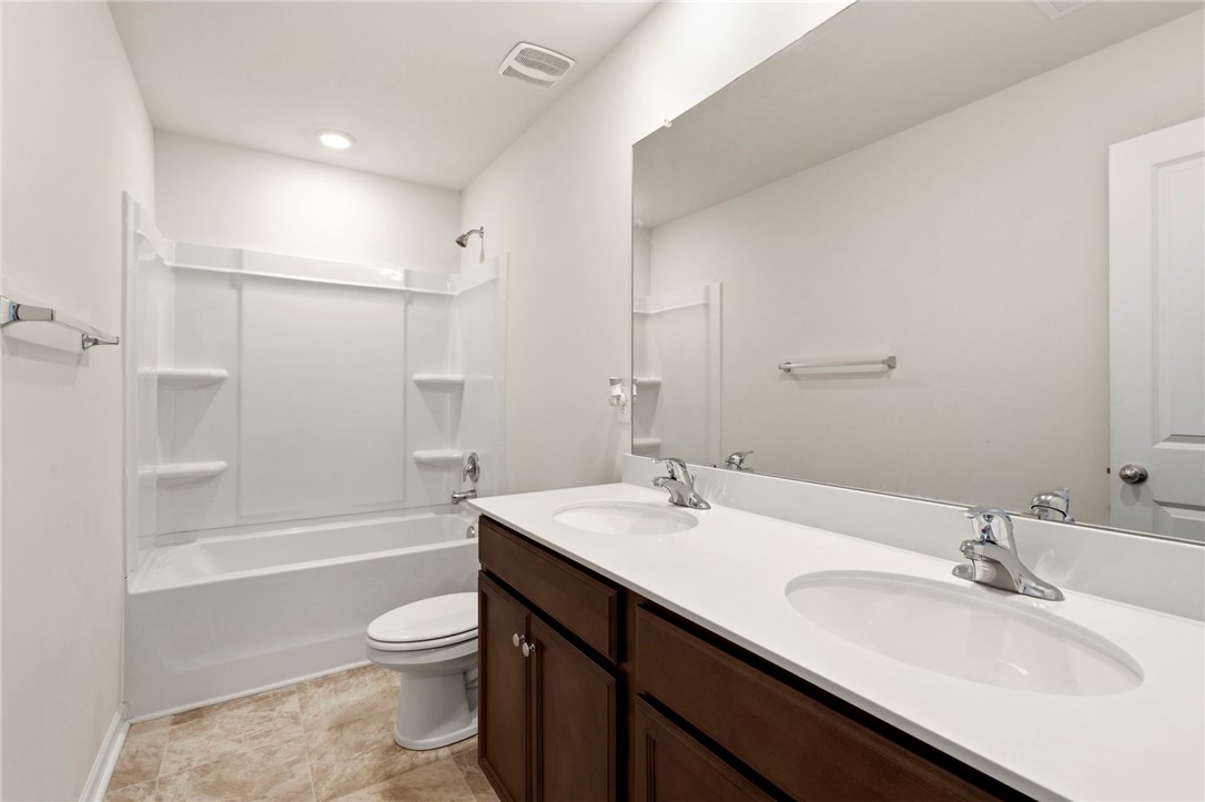 205 Hillendale Way Pelzer, SC 29669 - Photo 18 of 29 This spacious bathroom offers a double vanity and a shower-tub combination, perfect for daily routines.