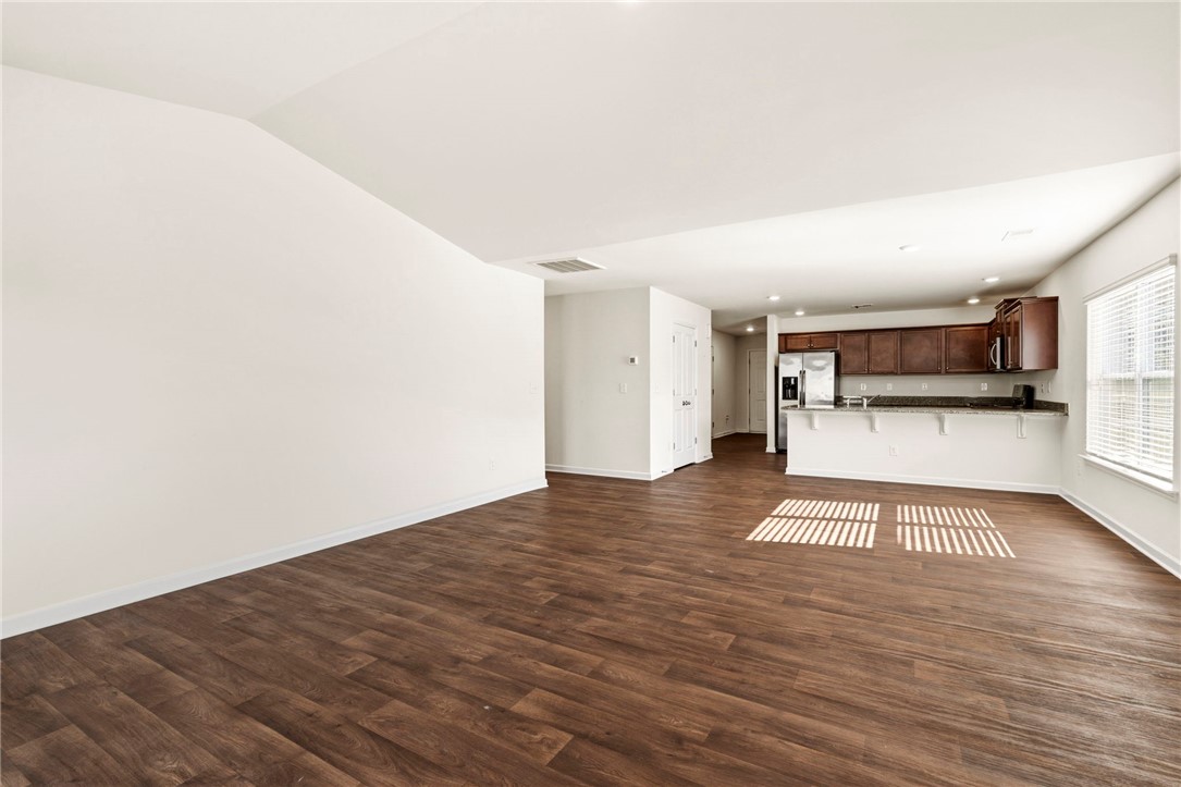 205 Hillendale Way Pelzer, SC 29669 - Photo 7 of 29 This versatile open-concept living area seamlessly connects to a modern kitchen, featuring sleek appliances.