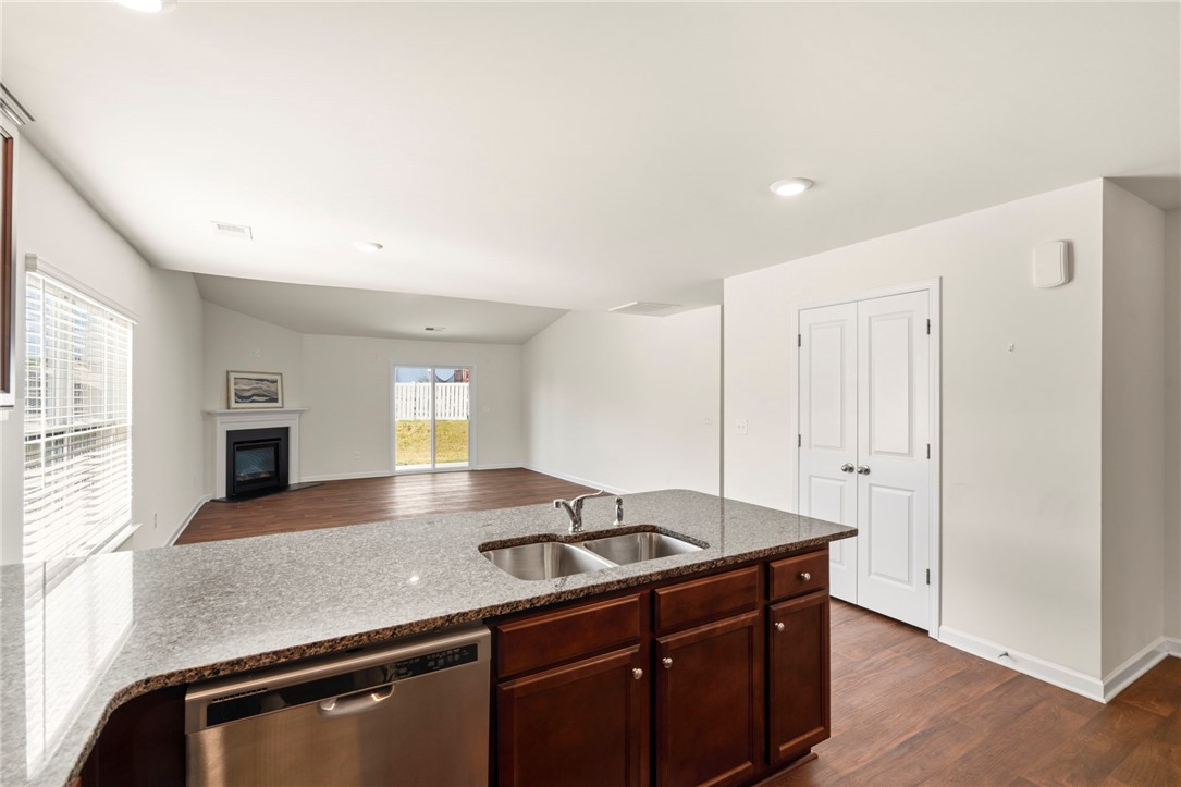 205 Hillendale Way Pelzer, SC 29669 - Photo 9 of 29 This open concept space features a kitchen island, a living area with a fireplace, and backyard access.
