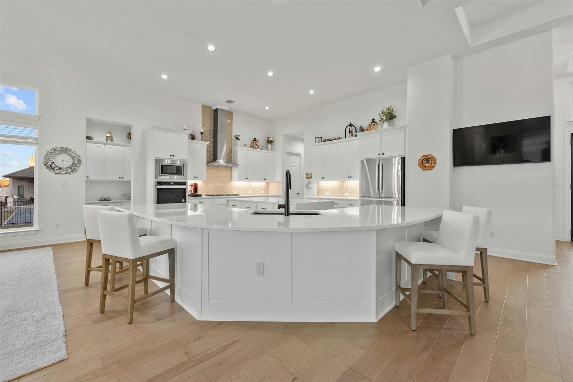 The gourmet kitchen, boasting double islands, a sprawling breakfast bar, elegant quartz countertops, and high-end stainless-steel appliances, creating a culinary haven.
