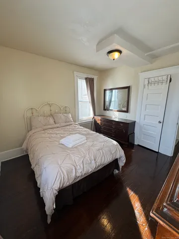 a bedroom with a bed dresser and a window