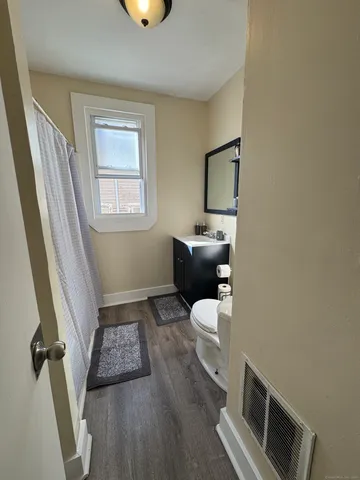 a bathroom with a toilet sink and mirror