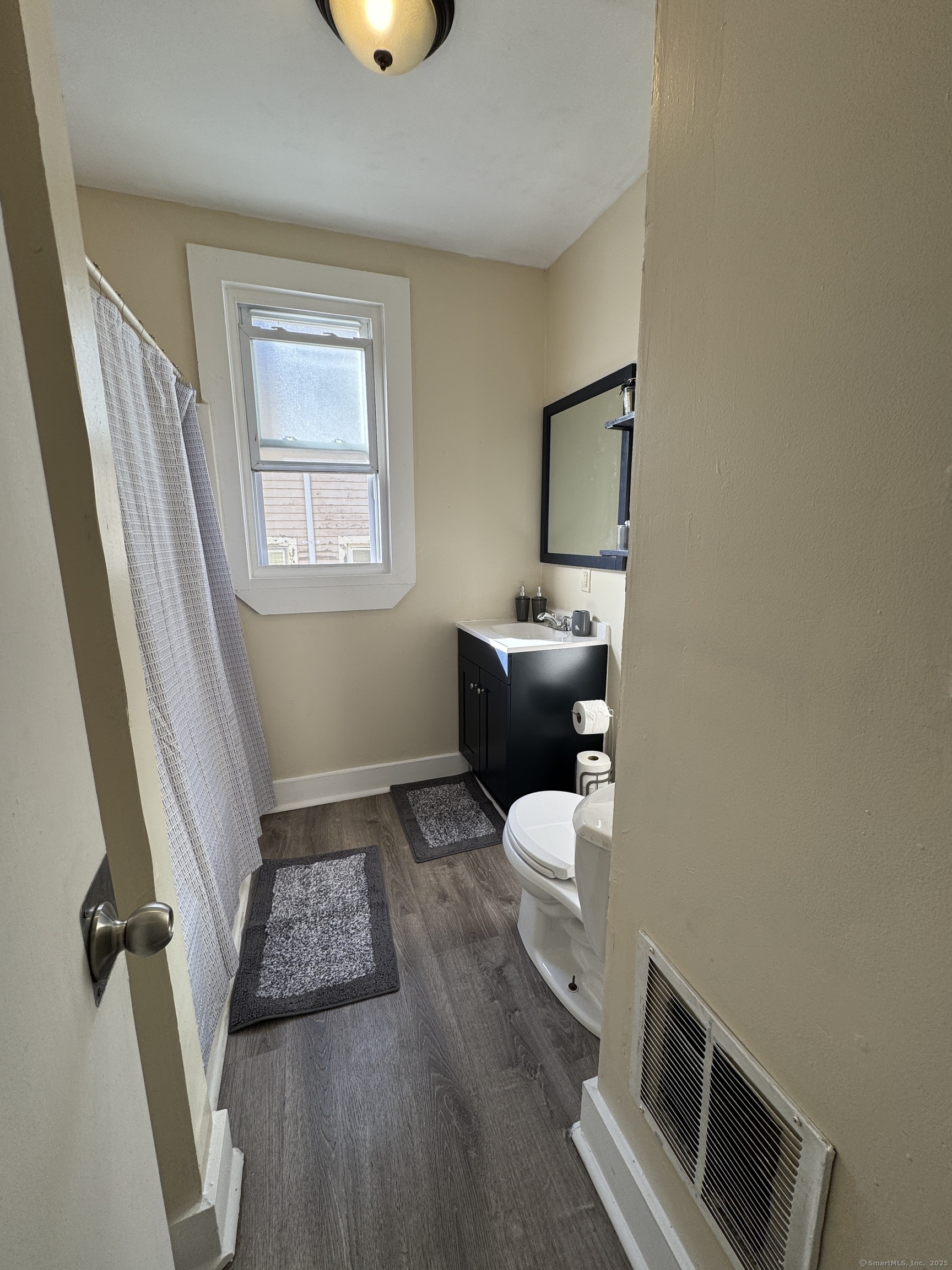 766 George Street, Unit 2 New Haven, CT 06511 - Photo 10 of 20 a bathroom with a toilet sink and mirror