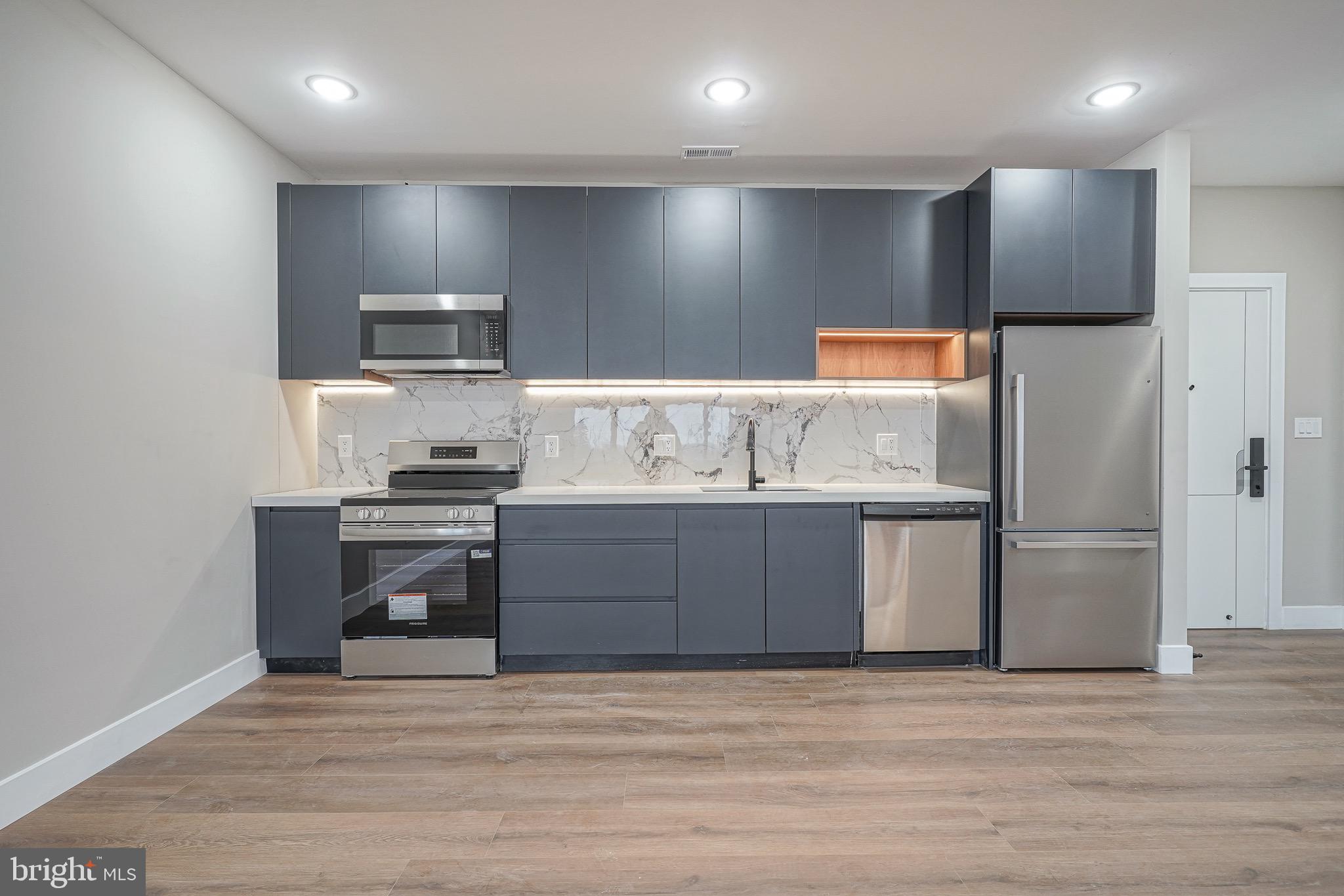 4432-00 Wingate Street, Unit 202 Philadelphia, PA 19136 - Photo 4 of 32 a kitchen with kitchen island stainless steel appliances a sink and refrigerator