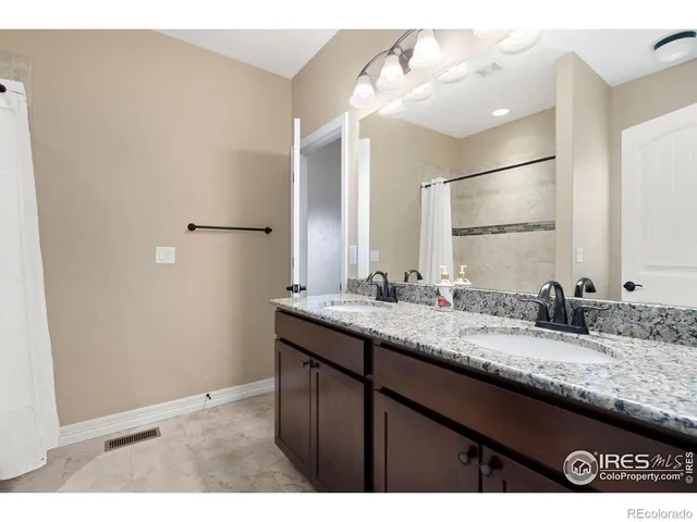 a bathroom with a double vanity sink and a mirror