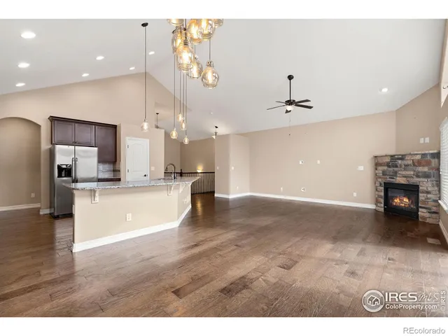 a kitchen with granite countertop a stove a sink and a refrigerator