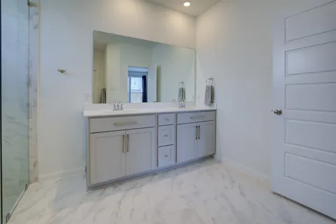 a spacious bathroom with a double vanity sink and mirror