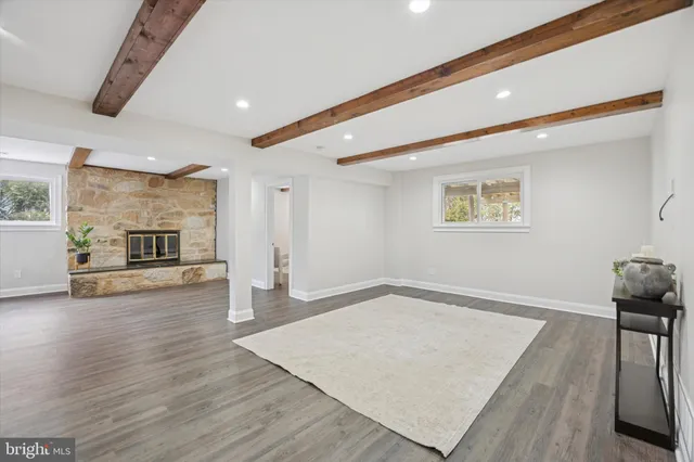a view of an empty room with window and wooden floor