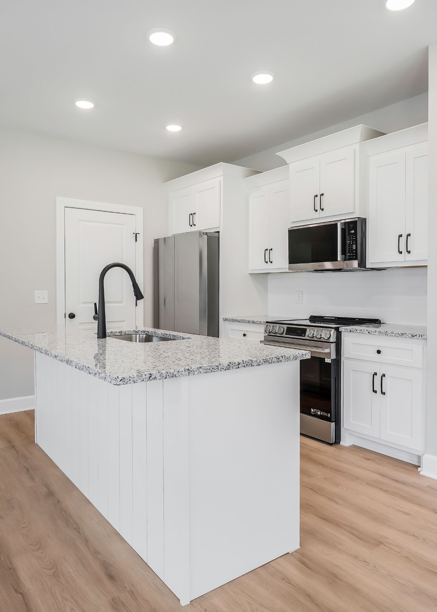 117 Reece Road Baxter, TN 38544 - Photo 21 of 31 a kitchen with stainless steel appliances granite countertop a stove top oven a sink a refrigerator and white cabinets