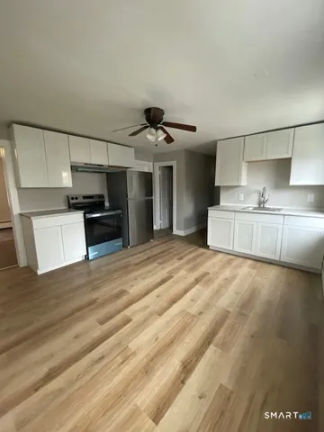 a view of a kitchen with a sink and a refrigerator