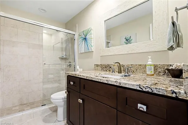 a bathroom with a granite countertop sink toilet and shower