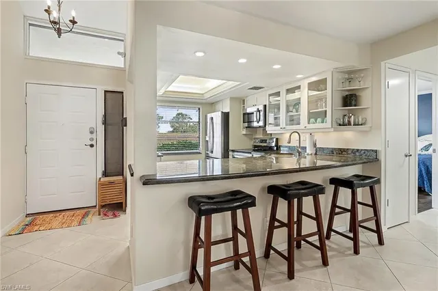 a kitchen with a table chairs refrigerator and cabinets