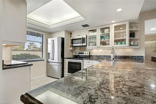 a kitchen with granite countertop a stove and refrigerator