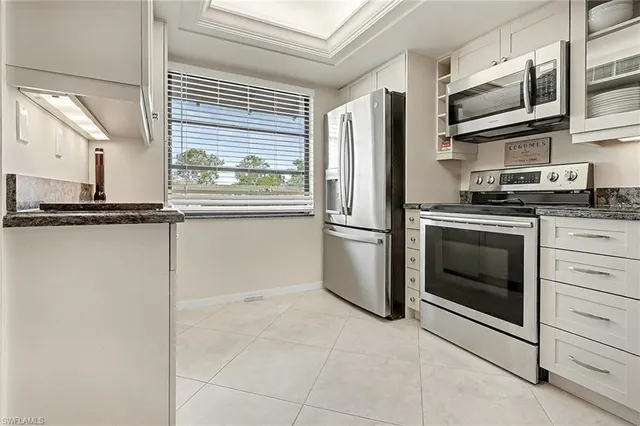 a kitchen with granite countertop a sink stainless steel appliances and cabinets
