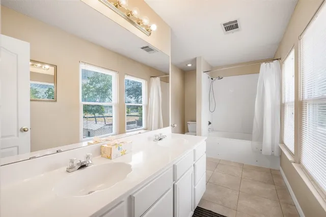 a bathroom with a bathtub a sink and a large mirror