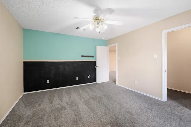 a view of an empty room with a ceiling fan