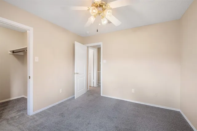 a view of an empty room and chandelier fan
